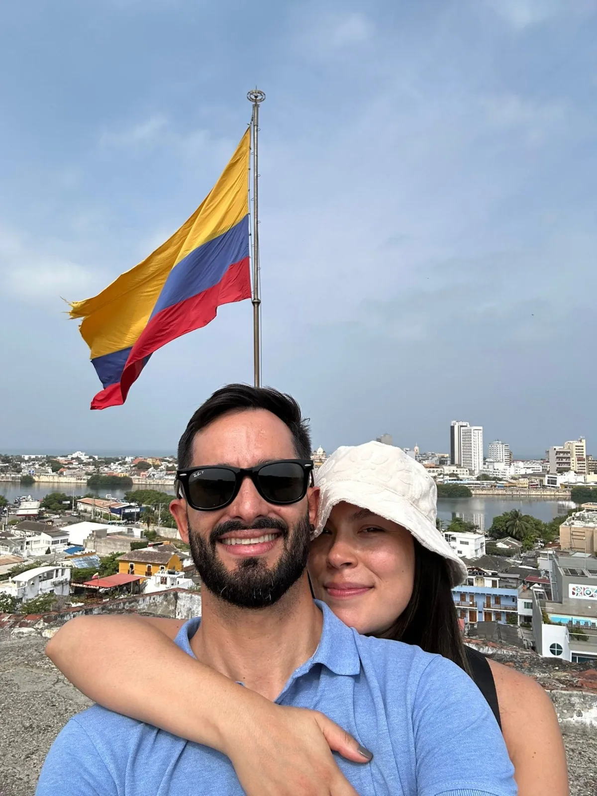 Carolina y Nacho en el mirador de Cartagena con la bandera de Colombia